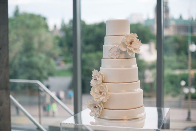 Eight tier wedding cake with gold accents and beautiful white peonies.